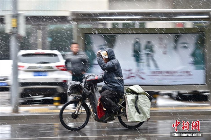 北京迎来今冬首场降雪 人们换上冬衣 