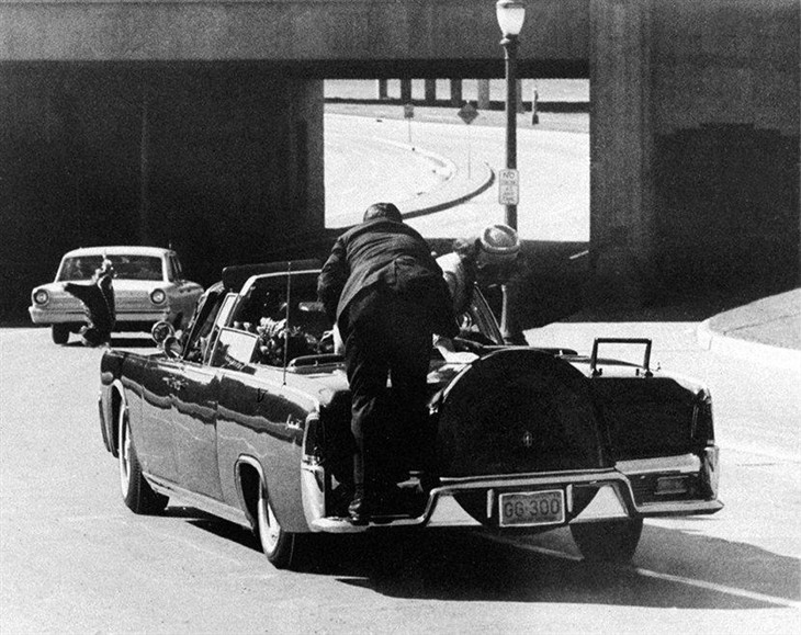 甘迺迪乘坐一辆敞蓬汽车游街拜会市民期间,被埋伏的枪手向他开枪,第一